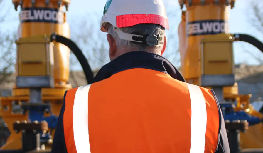 The back of a Selwood employee as he works on a pump installation