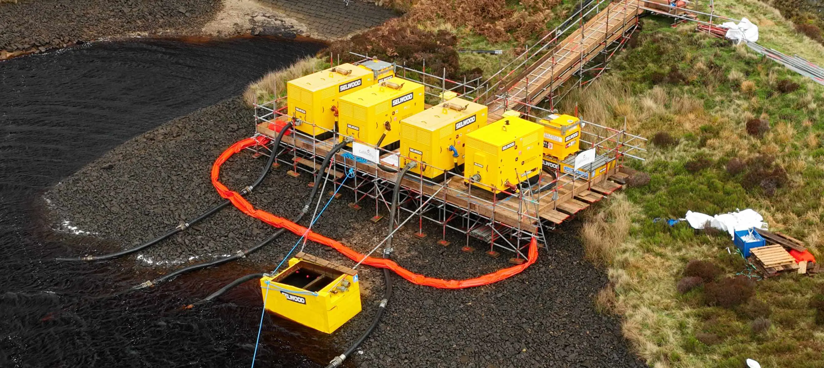 Four yellow Selwood pumps in operation at a reservoir