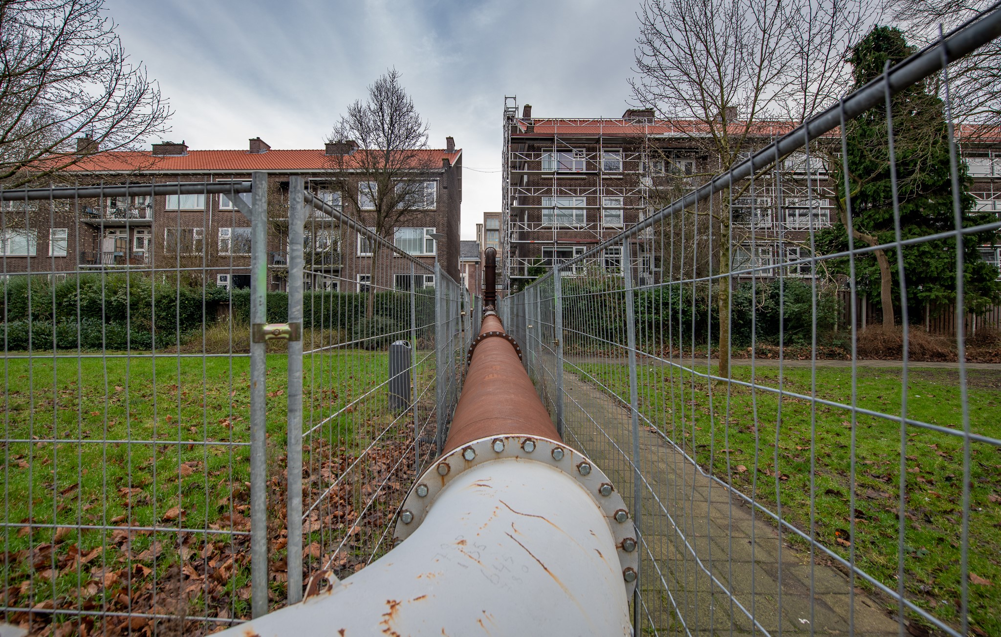 Een buis die loopt door een steeg in Rotterdam van een TPI van Vanderkamp