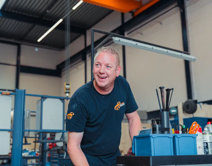 Gerard lachend kijkend in werkplaats