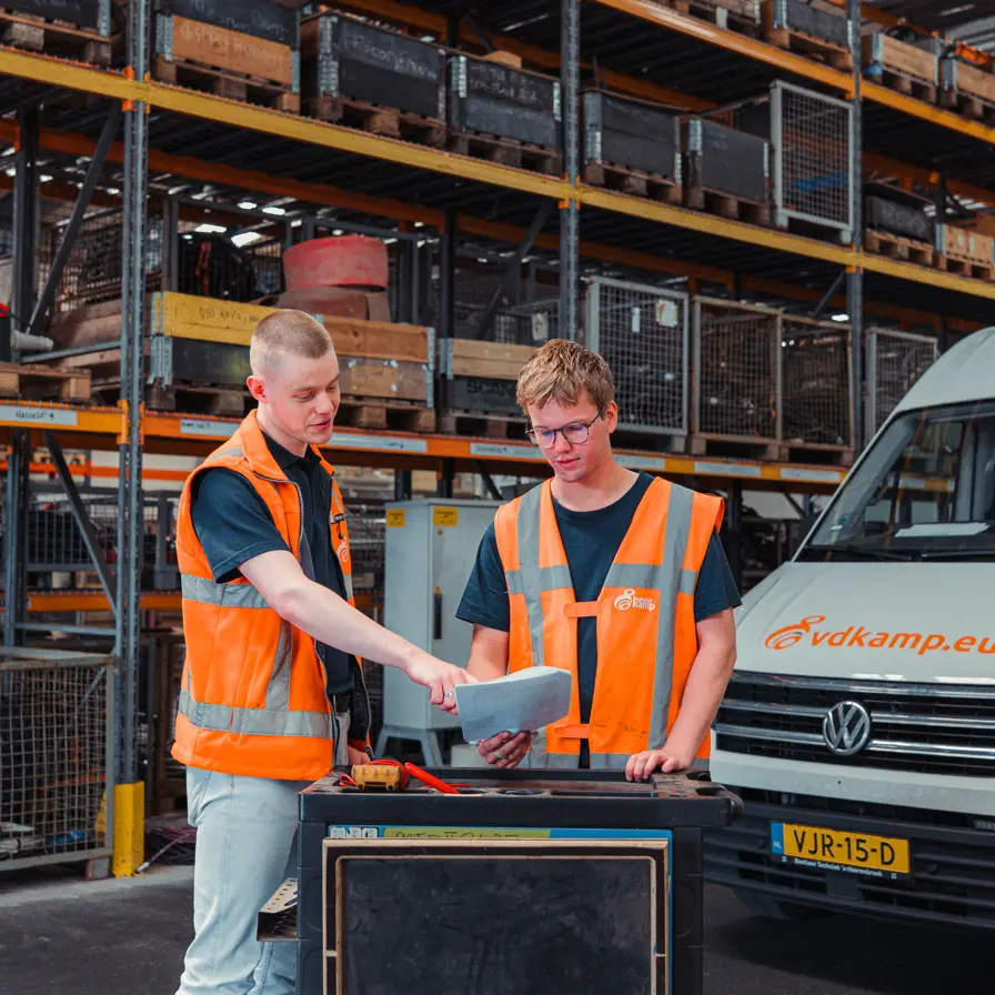 Tomas en Bart-jan kijkend naar papier voor Vanderkamp auto