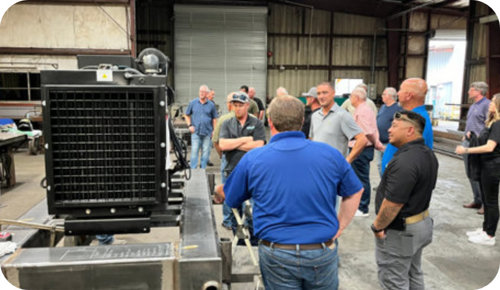 Holland Pump employees looking at a pump and engine